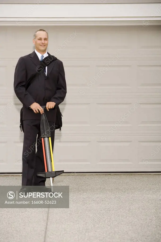 Two businesspeople with one on a pogo stick