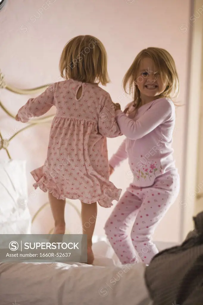 Two girls playing on bed
