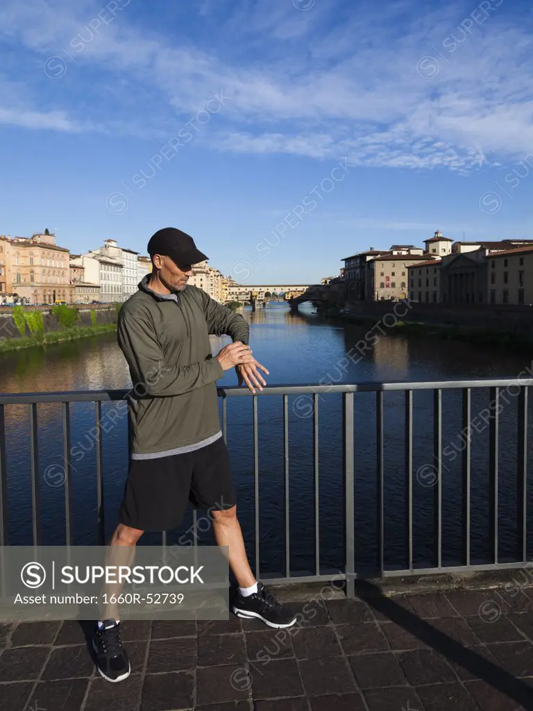 Italy, Florence, Man checking time on bridge over River Arno