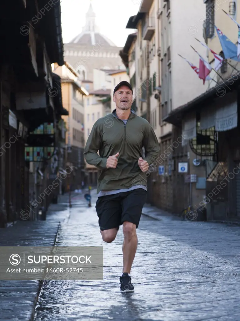 Italy, Florence, Man jogging in city