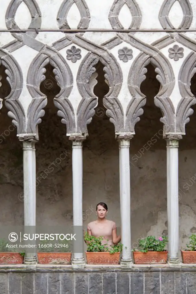 Italy, Ravello, Woman standing on balcony between ornate columns