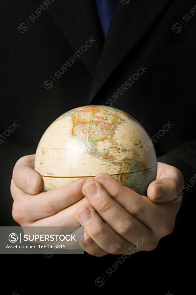 Mid section view of a businessman holding a globe