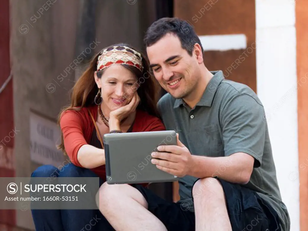 Italy, Venice, Mature couple using digital tablet