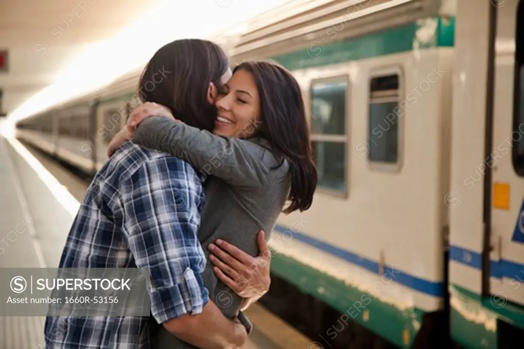 Italy, Venice, Young couple embracing on railway station