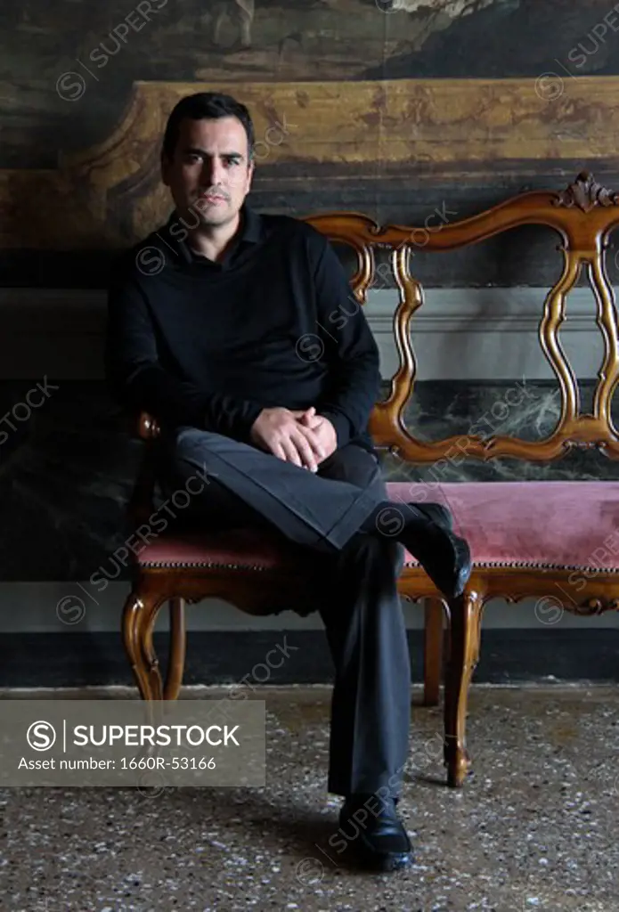 Italy, Venice, Portrait of man sitting on old chair