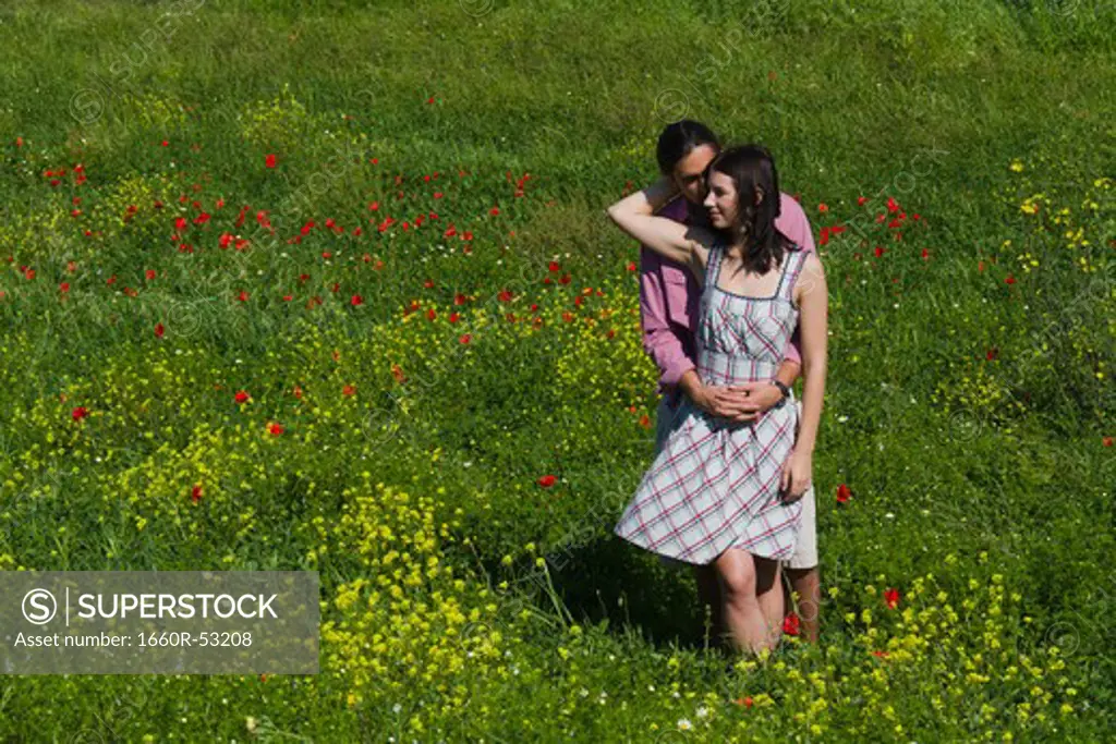 Italy, Tuscany, Young couple embracing on meadow