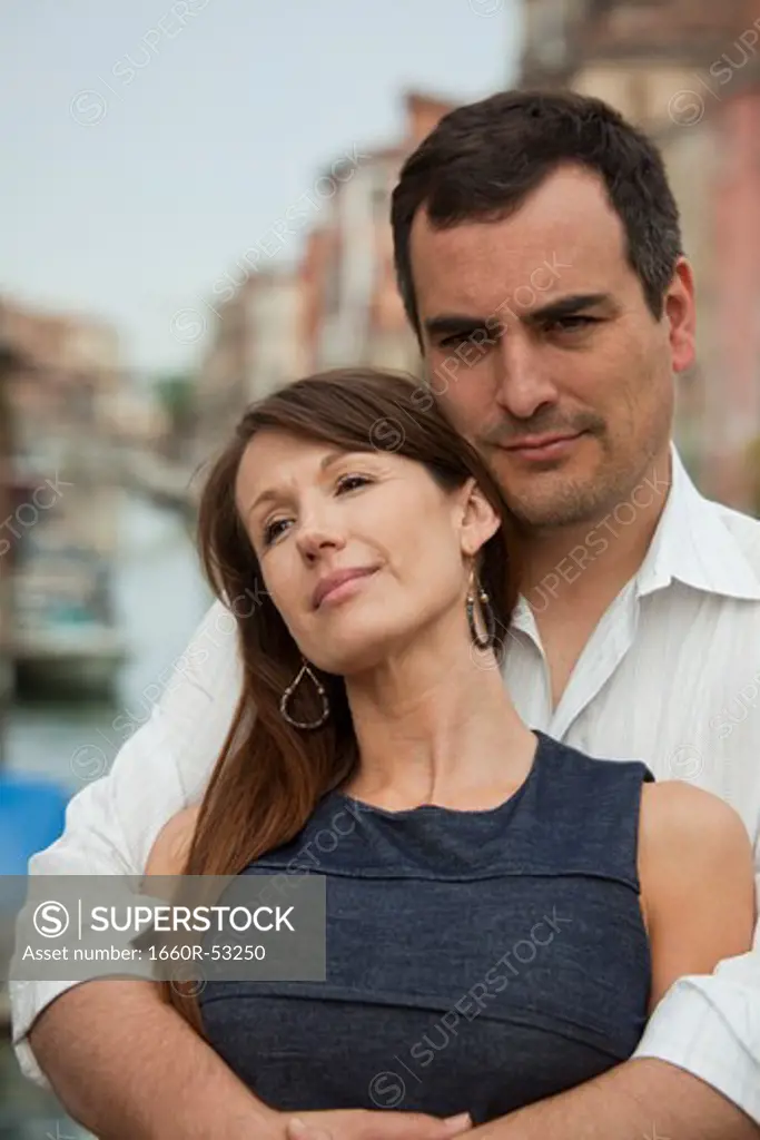 Italy, Venice, Romantic couple standing on bridge over canal