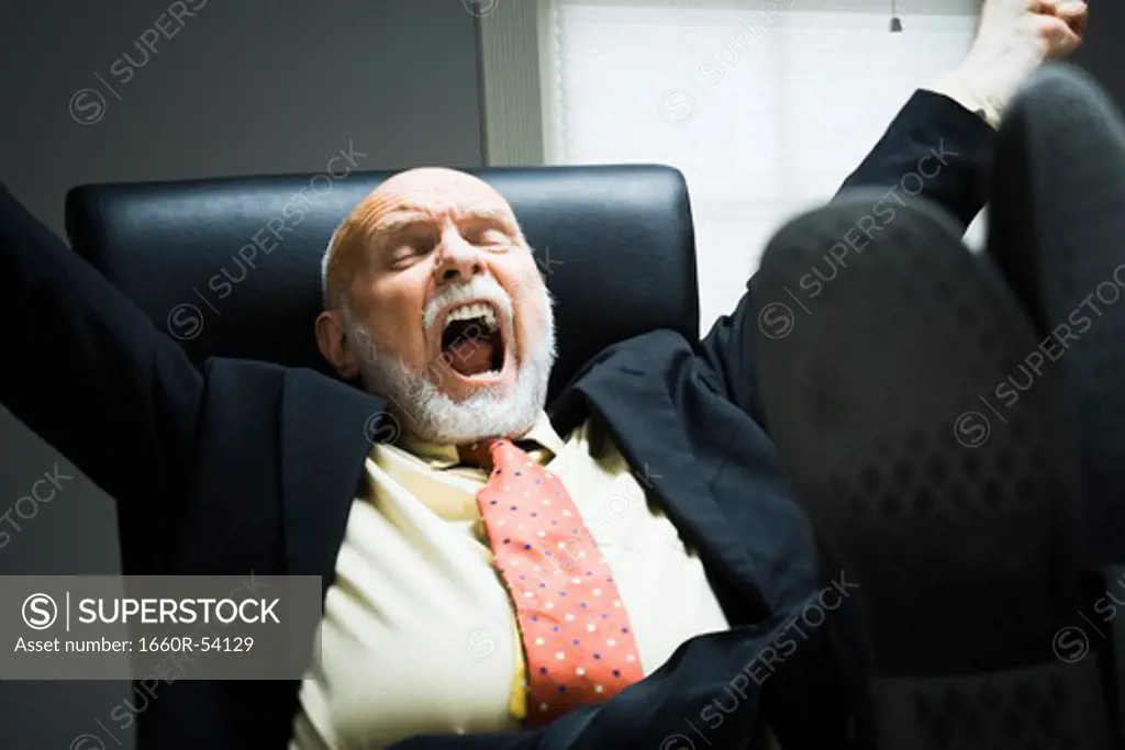 Closeup of businessman yawning in office