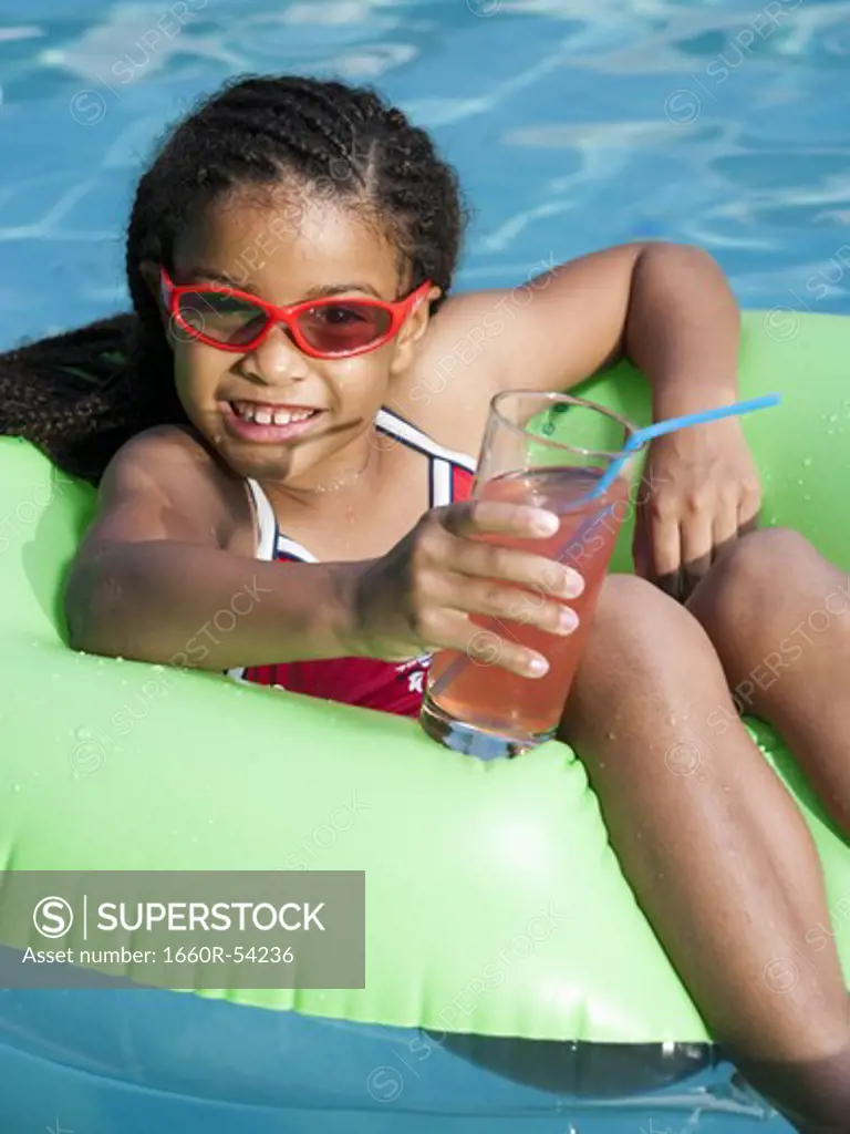 Girl on pool lounger with pink lemonade