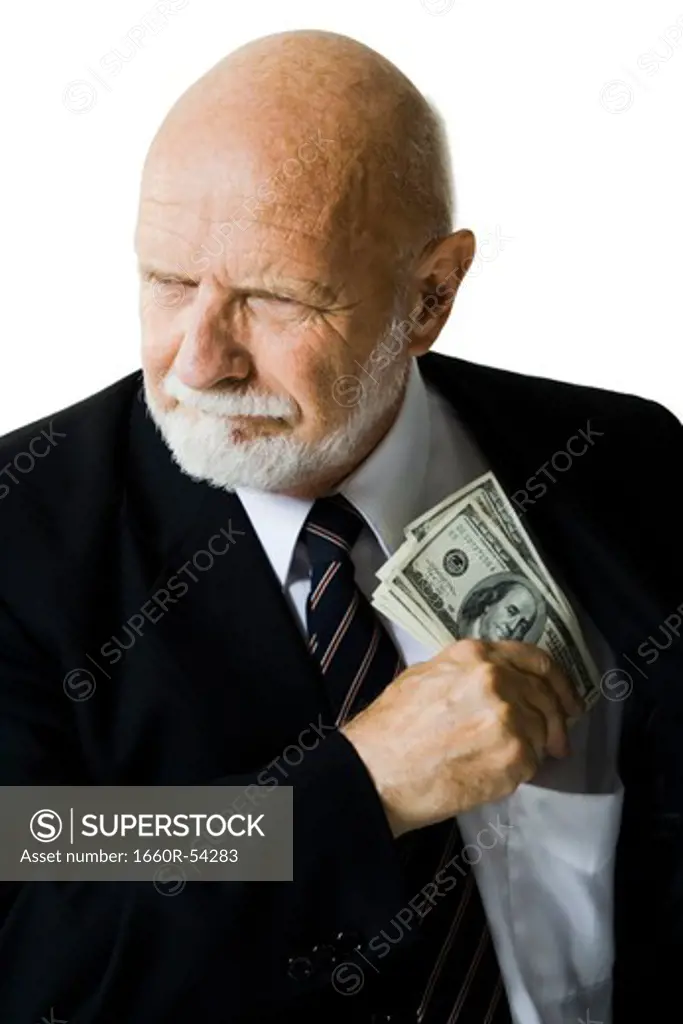 Closeup of businessman putting US banknotes in pocket