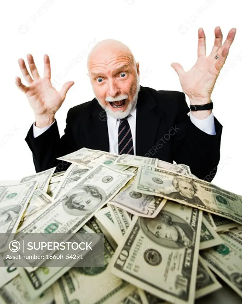 Closeup of businessman looking at pile of money