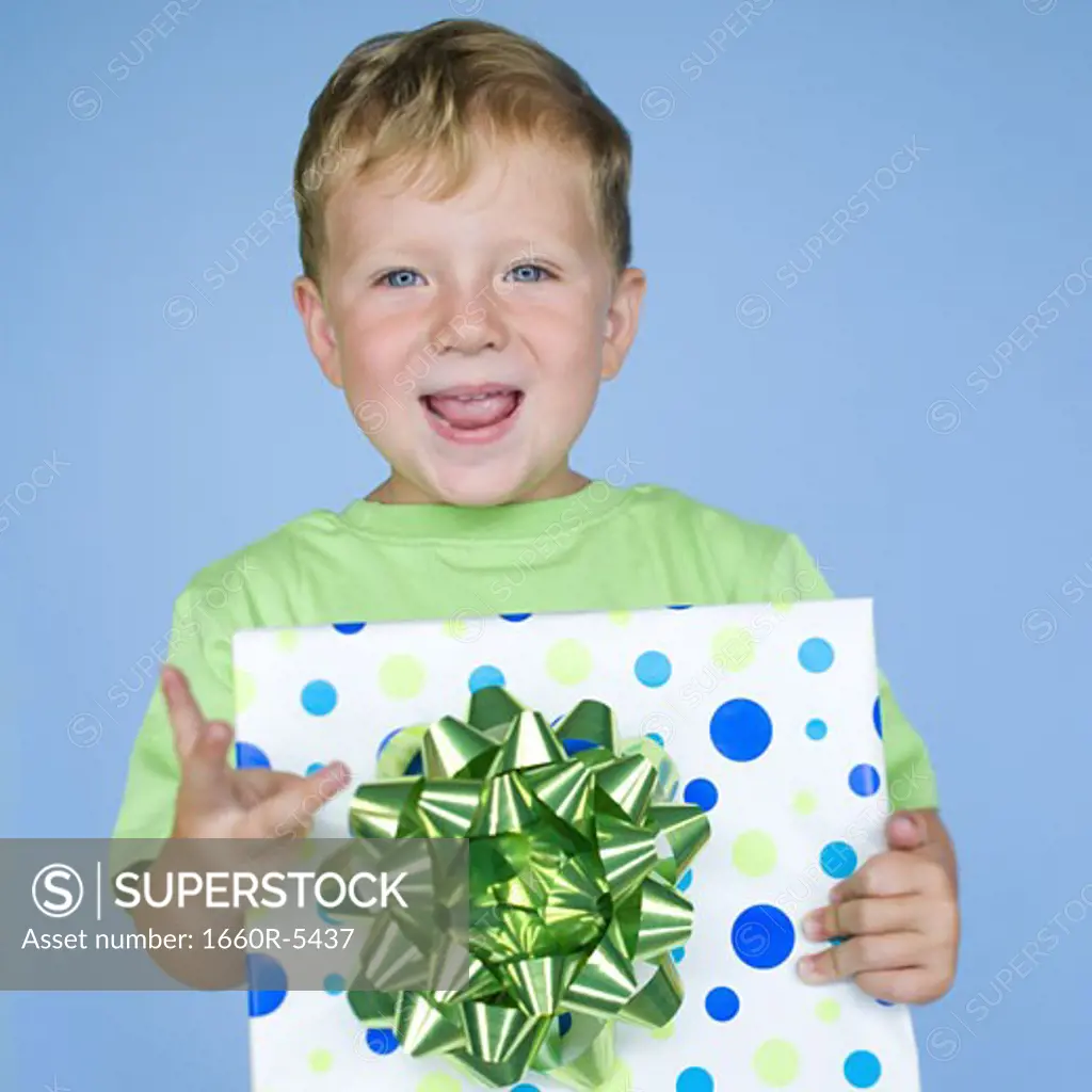 Portrait of a boy holding a gift and smiling