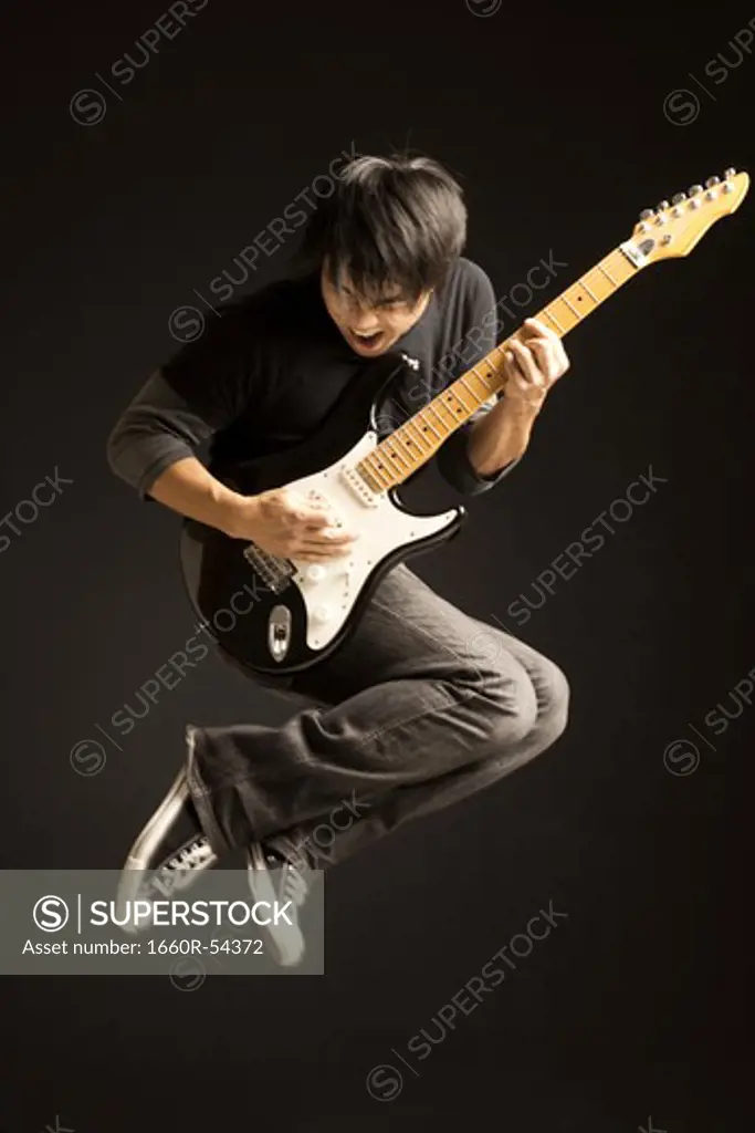 Portrait of young man playing electric guitar