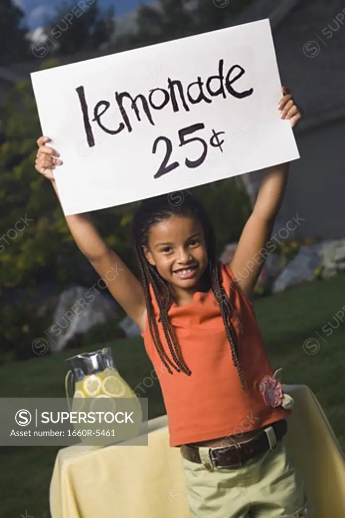 Portrait of a girl holding a lemonade sign and smiling