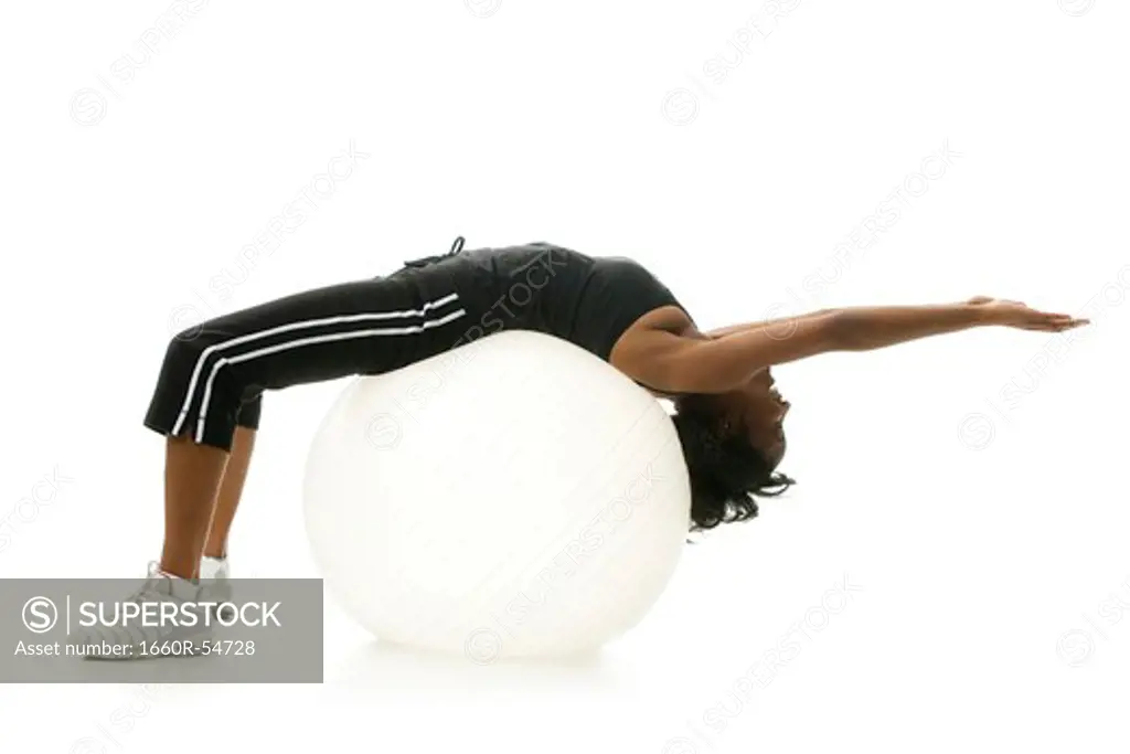 Woman stretching on pilates ball
