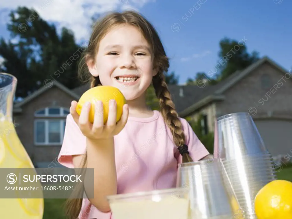 Young girl with lemonade stand and money jar