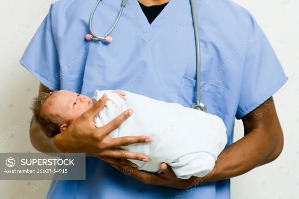 Male Doctor smiling at newborn baby