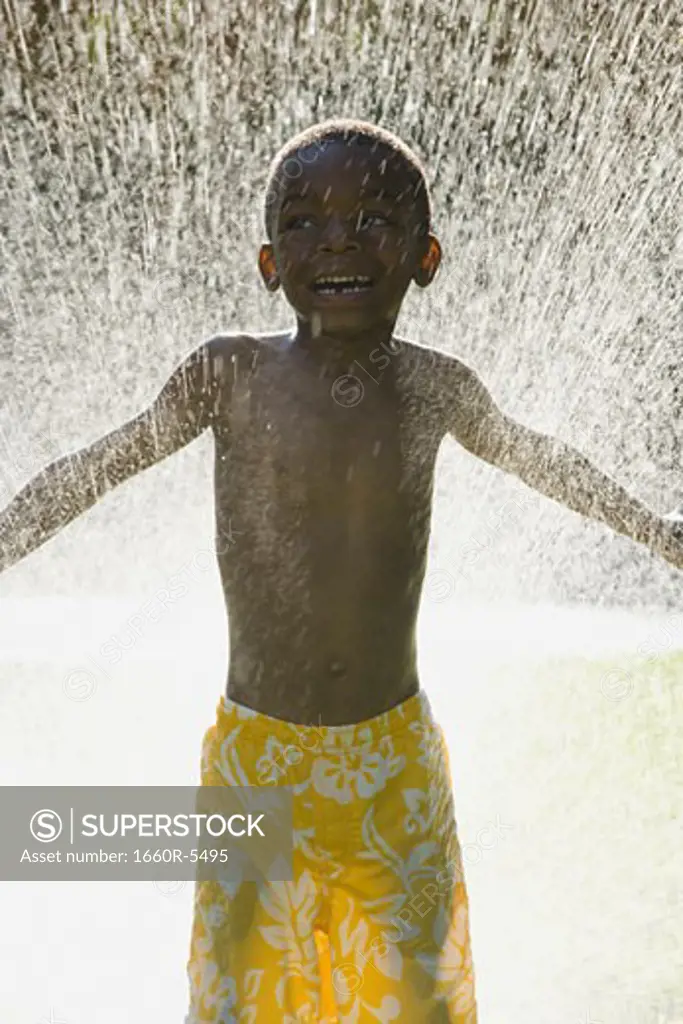 Boy standing in front of a spray of water