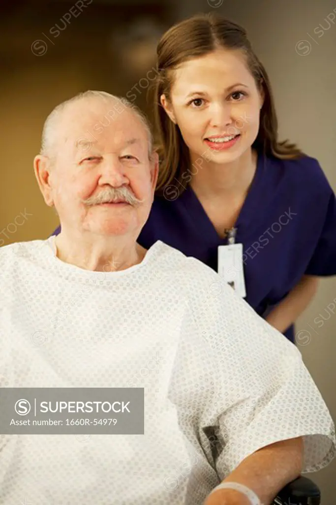 Mature man in wheelchair with nurses smiling