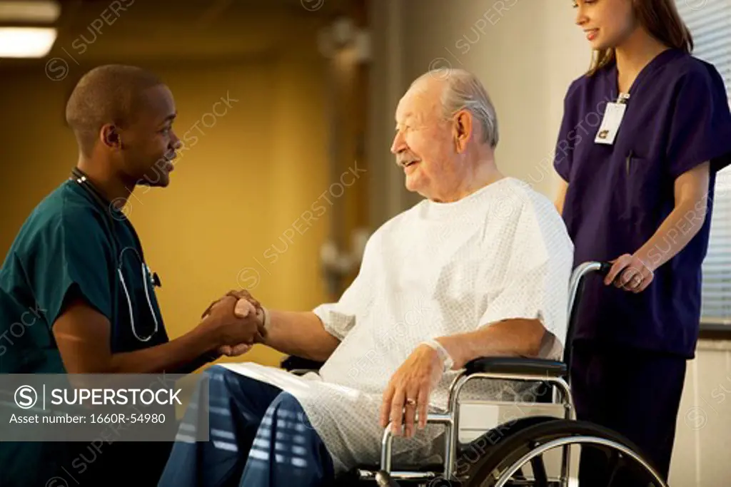 Mature man in wheelchair with doctor and nurse