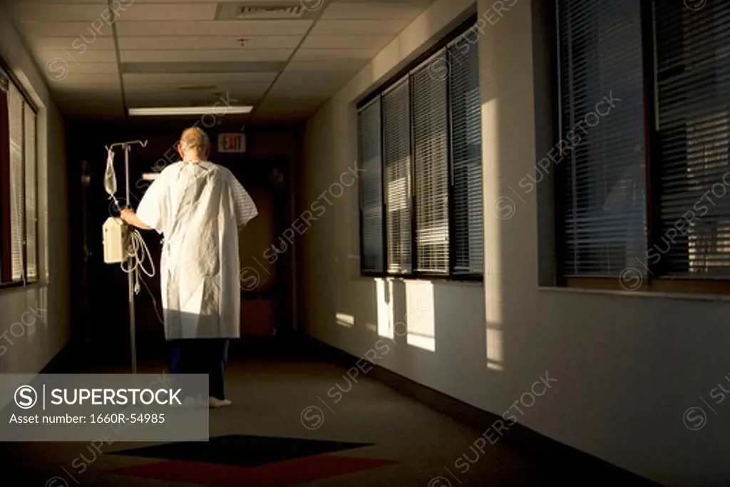 Mature man walking with IV Stand from behind