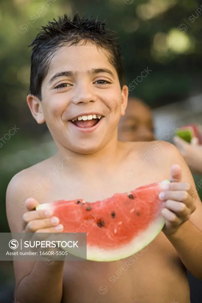 Portrait of a boy holding a slice of a watermelon