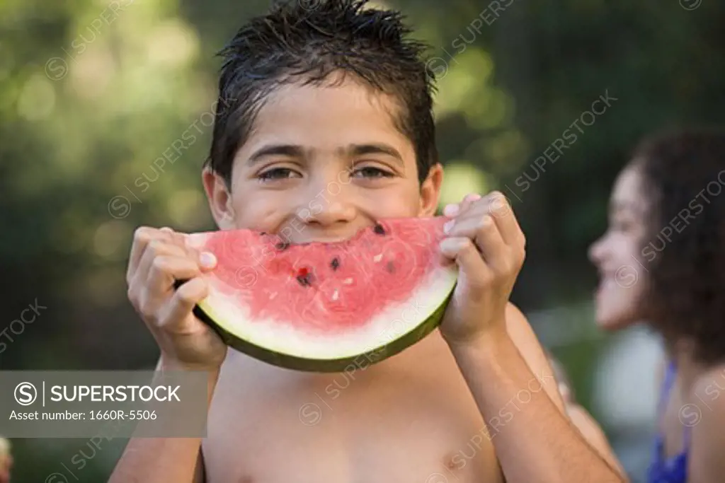 Portrait of a boy eating a watermelon