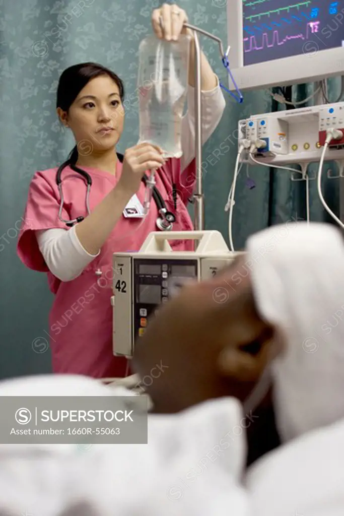 Nurse adjusting IV bag for patient