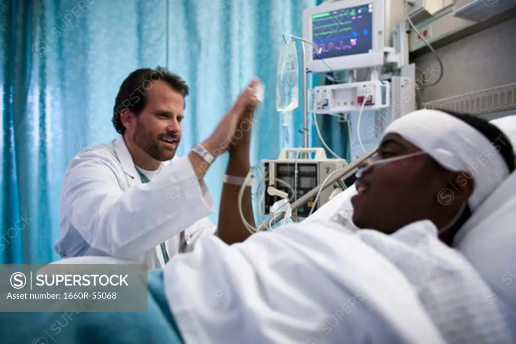 Doctor talking to boy in hospital bed