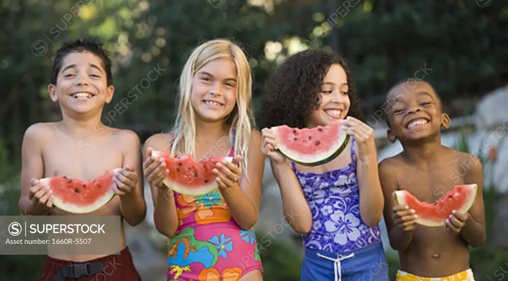 Close-up of children holding watermelons and smiling
