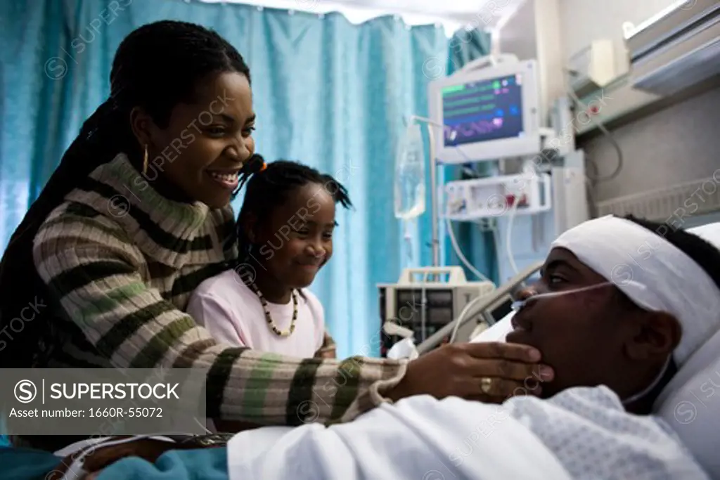 Family talking to boy in hospital bed