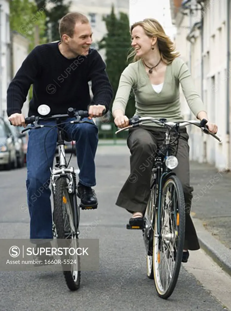 Young couple riding bicycles on a street