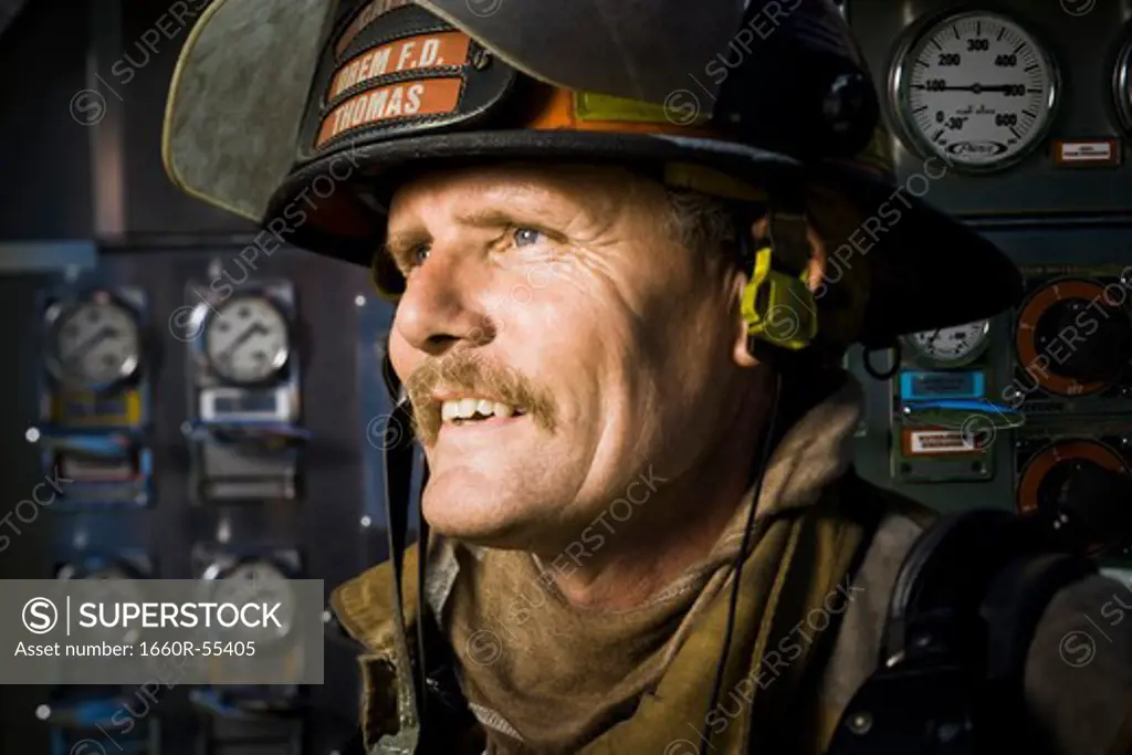 Portrait of a firefighter in front of control panel