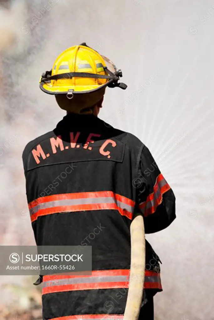 Rear View of a firefighter with hose