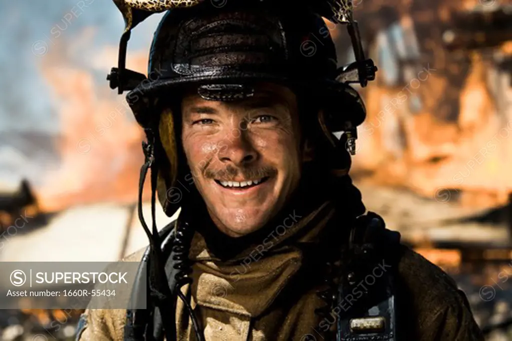 Portrait of a firefighter with fire in background