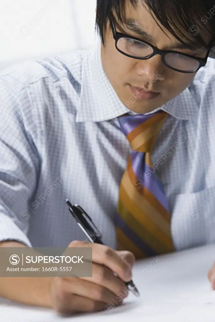 Close-up of a businessman writing with a pen