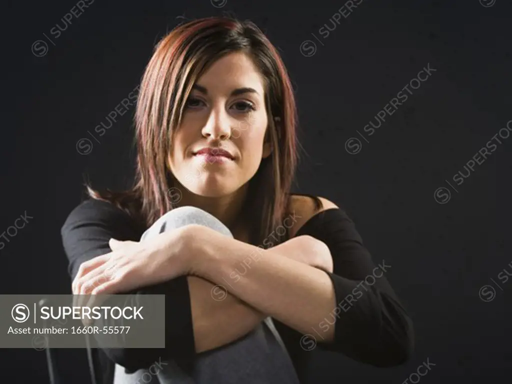 Woman in chair leaning on knee