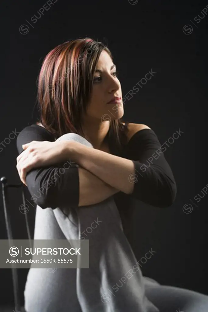 Woman in chair leaning on knee
