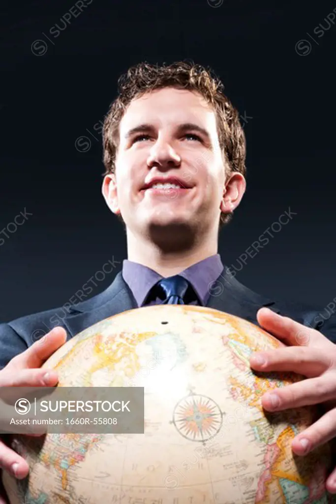 Businessman holding globe smiling