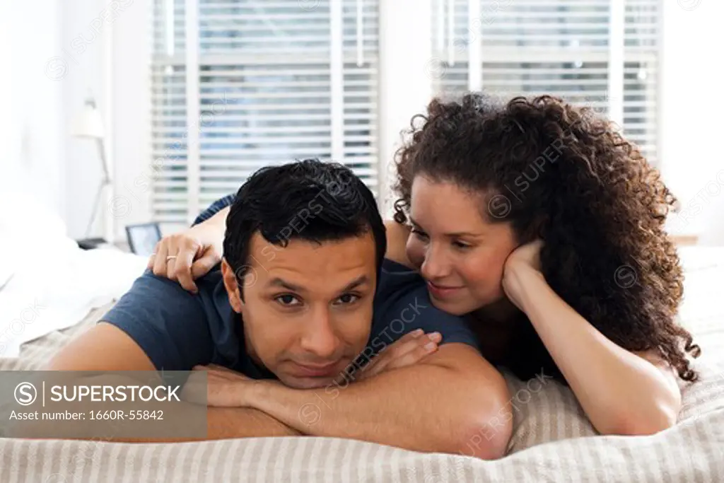 Man and woman on bed snuggling