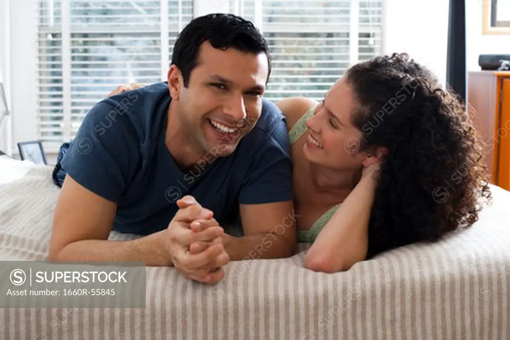 Man and woman on bed snuggling