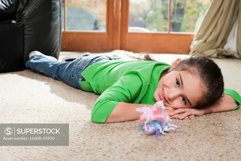 Young girl playing with toys on carpet