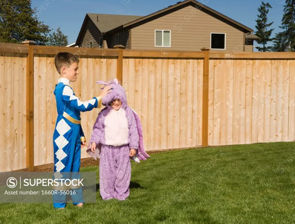 Girl and boy in yard in halloween costumes