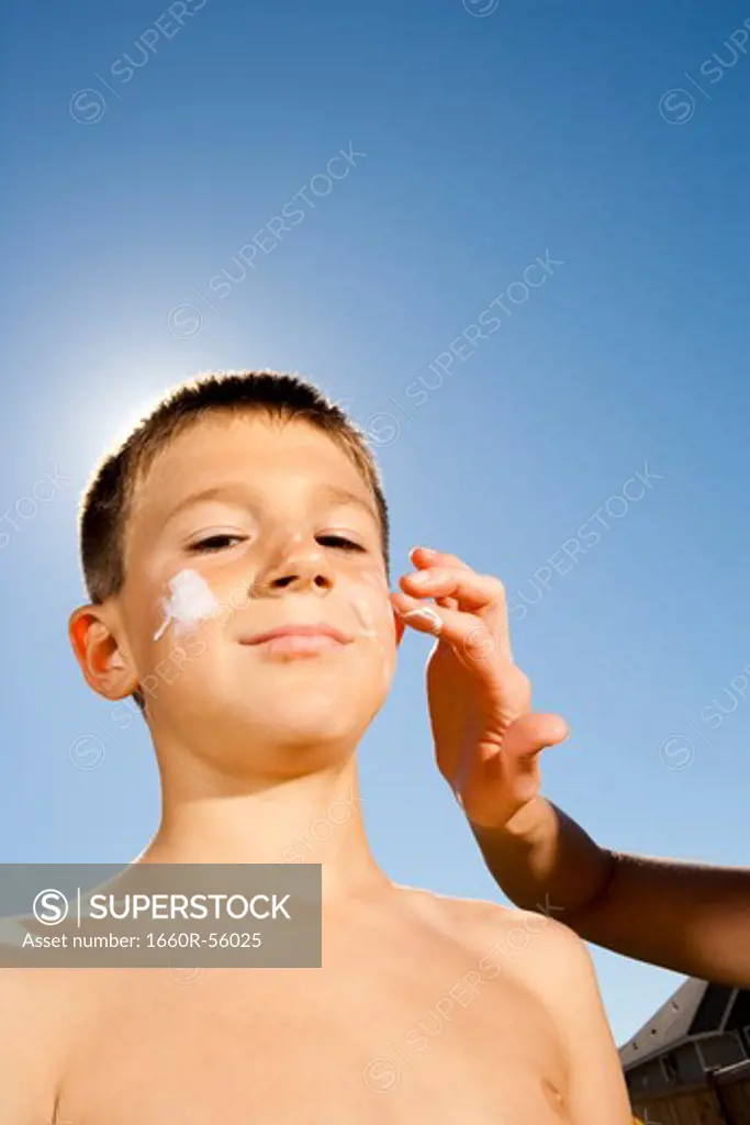 Boy with suntan lotion shouting
