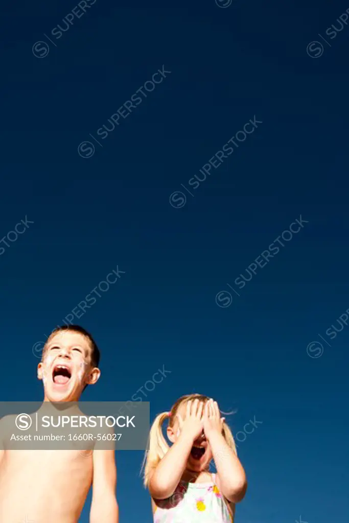 Boy and girl with sunscreen shouting