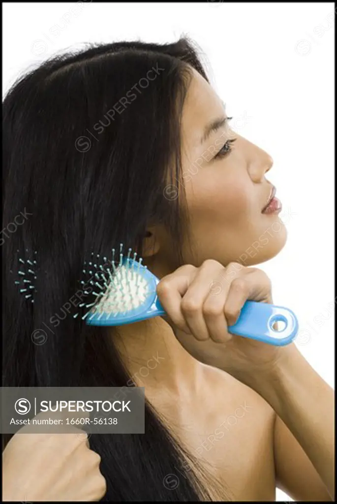 Smiling woman brushing hair