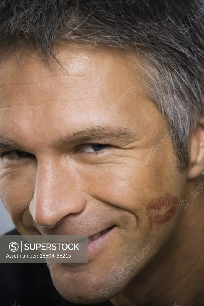 Closeup of mature man with lipstick kiss on cheek