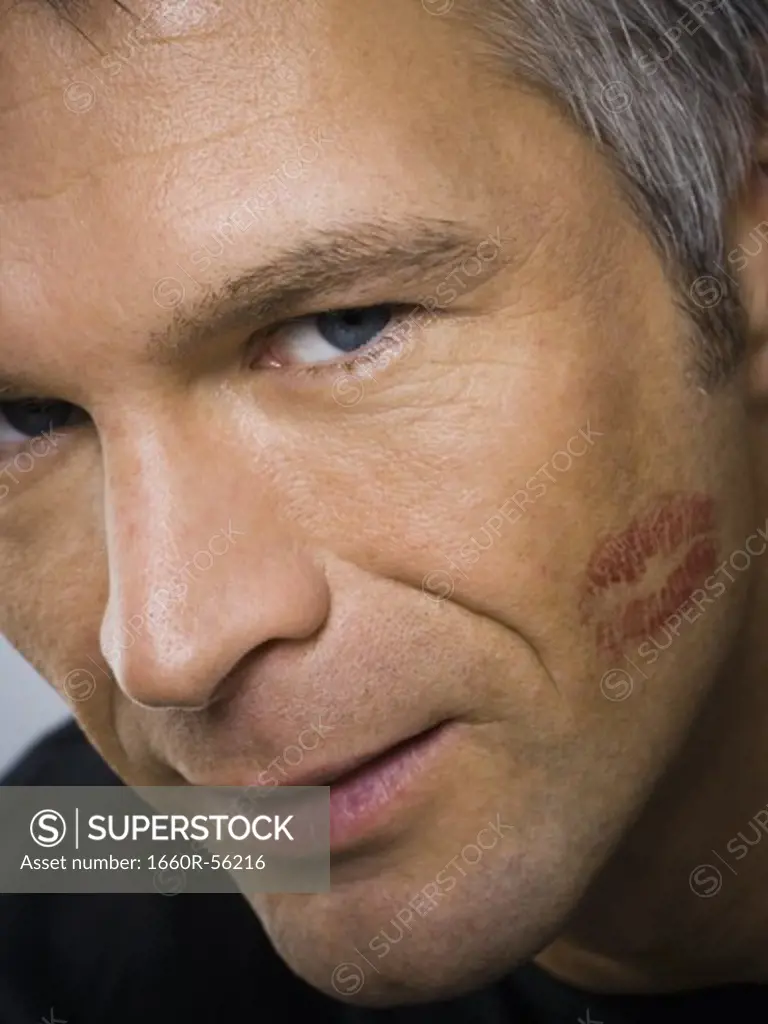Closeup of mature man with lipstick kiss on cheek