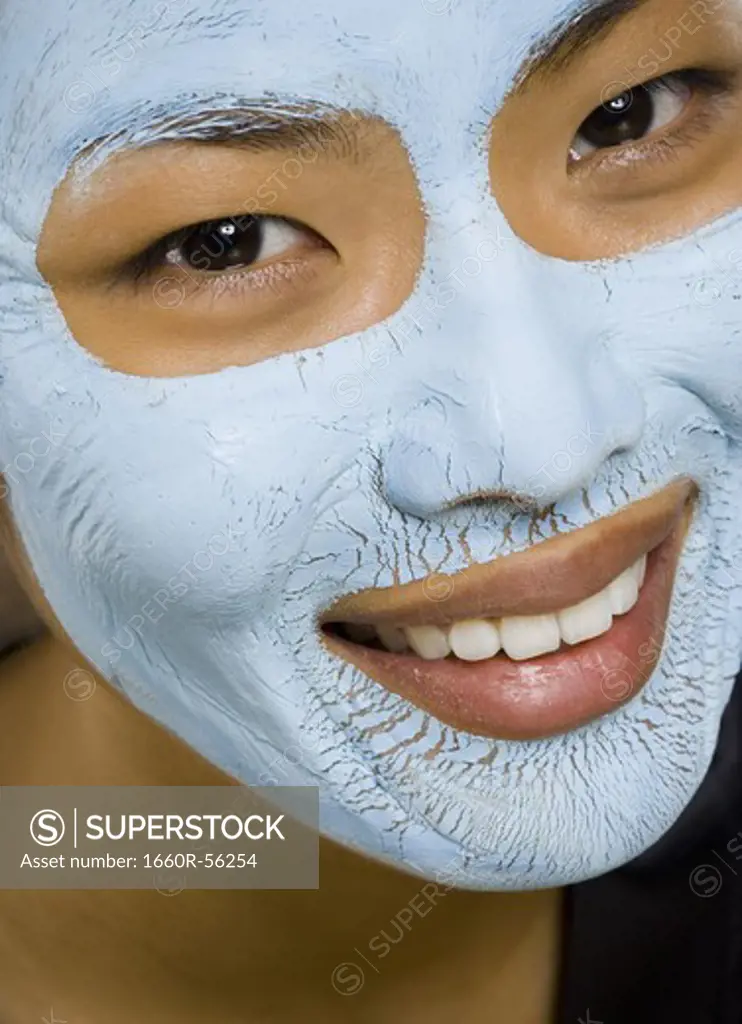Closeup of woman smiling with facial mask