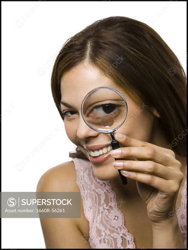 Closeup of woman looking through magnifying glass